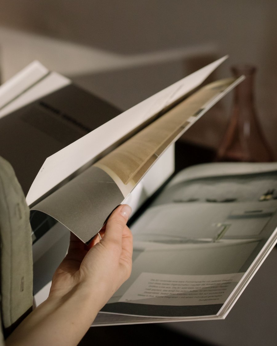 Hands leafing through a printed booklet