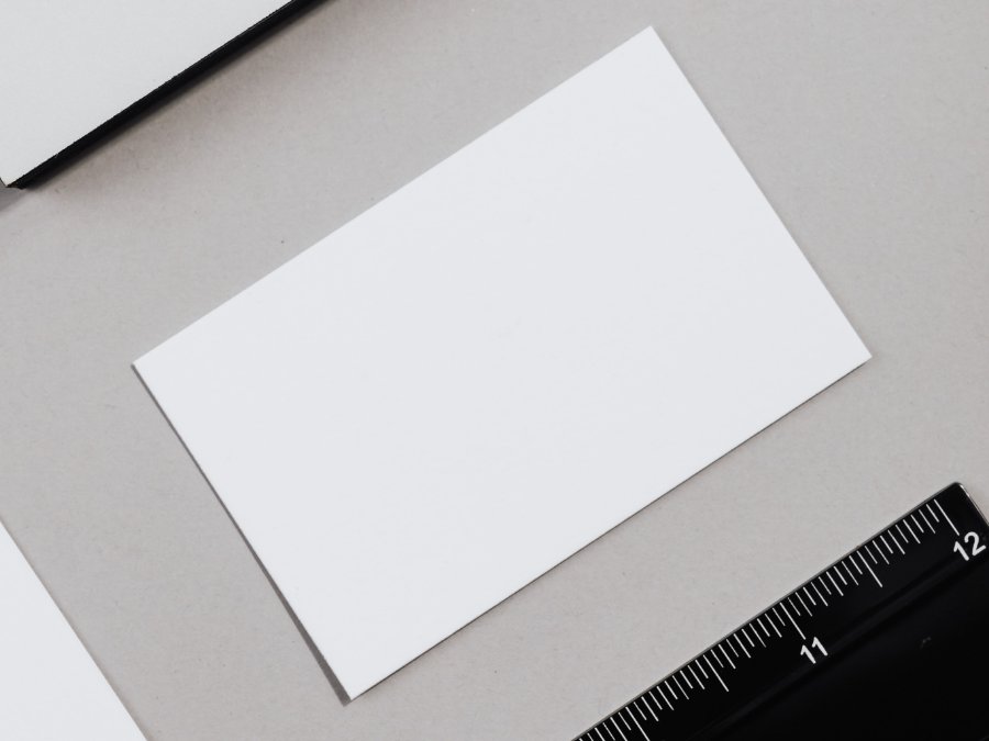 A business card measured against a steel rule